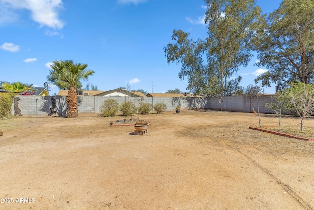 view of yard featuring a fire pit and a fenced backyard