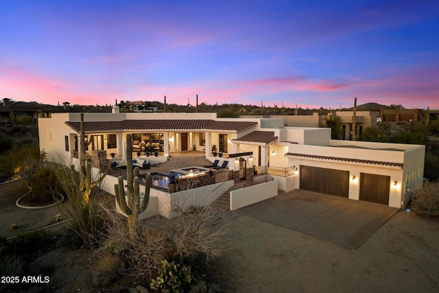 view of front of house featuring a patio, driveway, area for grilling, an attached garage, and stucco siding