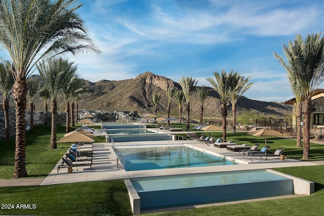 view of pool featuring a lawn and a mountain view