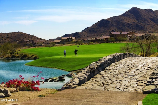 view of community with a yard and a water and mountain view