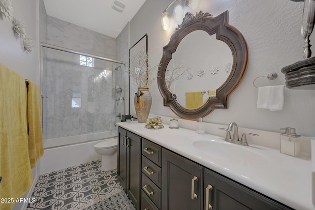 bathroom featuring visible vents, toilet, tile patterned flooring, combined bath / shower with glass door, and vanity