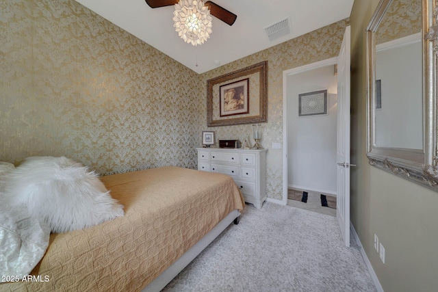 bedroom featuring light carpet, wallpapered walls, baseboards, visible vents, and ceiling fan