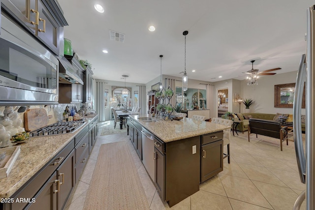 kitchen with light tile patterned floors, visible vents, stainless steel appliances, pendant lighting, and backsplash