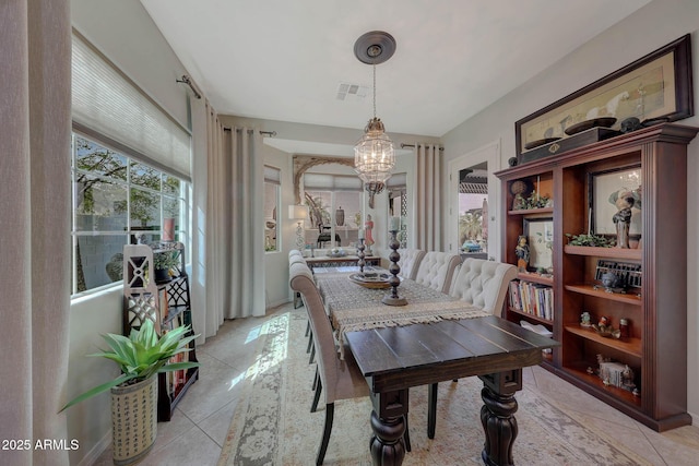 dining area with a chandelier, light tile patterned floors, and visible vents