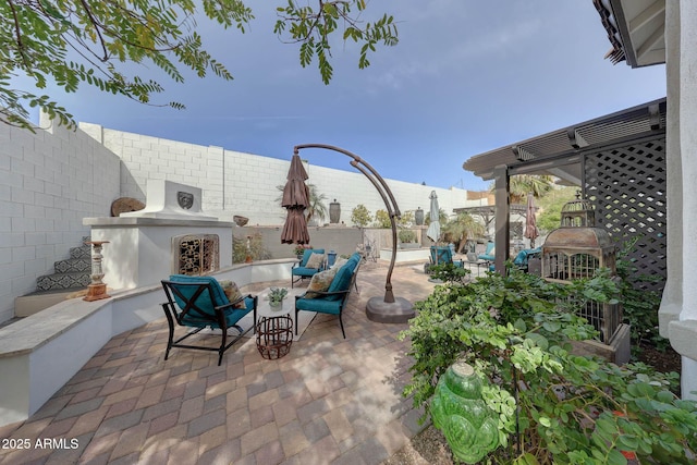 view of patio / terrace featuring exterior fireplace and a fenced backyard