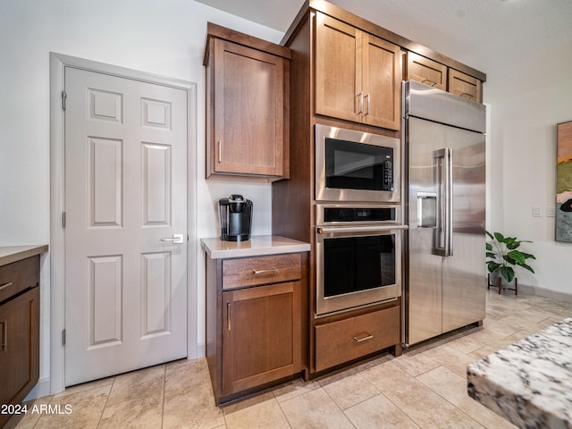 kitchen with light tile patterned floors and stainless steel appliances