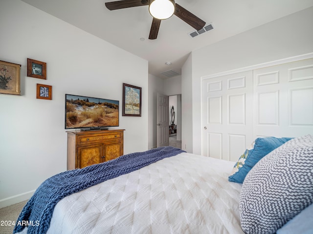 carpeted bedroom featuring ceiling fan and a closet