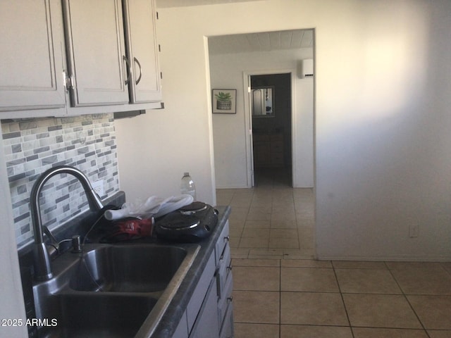 kitchen with sink, white cabinetry, backsplash, dark tile patterned flooring, and an AC wall unit