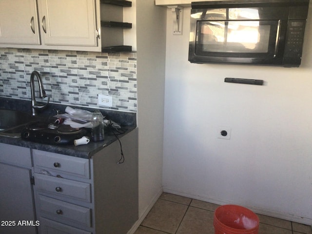 kitchen with white cabinetry, sink, decorative backsplash, and light tile patterned floors