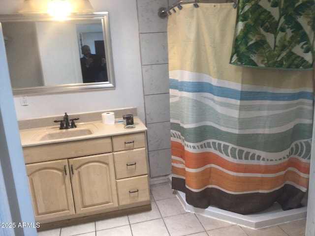 bathroom with tile patterned flooring, vanity, and walk in shower