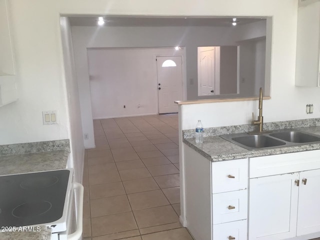 kitchen featuring white cabinetry, white range with electric cooktop, tile patterned flooring, and sink