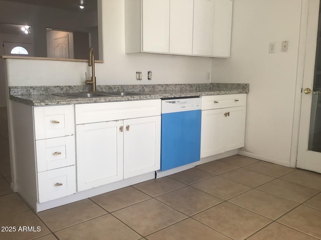 kitchen featuring dishwashing machine, sink, white cabinetry, and tile patterned floors