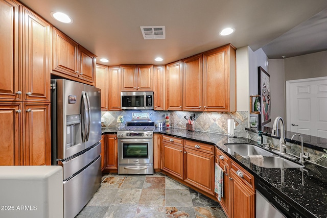 kitchen with decorative backsplash, visible vents, stainless steel appliances, and a sink