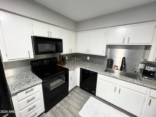 kitchen with black appliances, white cabinetry, and sink