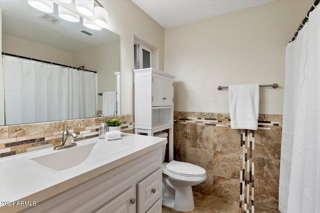 bathroom featuring tile walls, vanity, a notable chandelier, and toilet