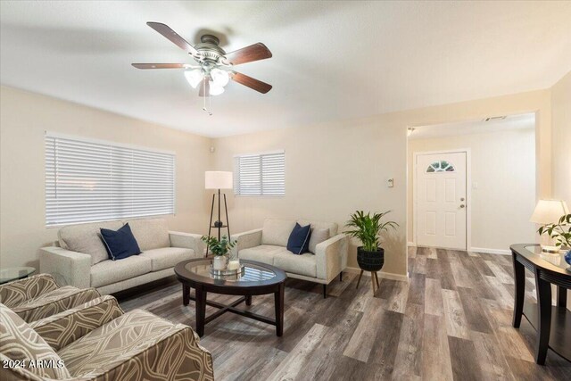 living room with ceiling fan and dark hardwood / wood-style flooring