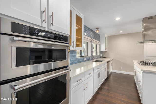 kitchen with appliances with stainless steel finishes, dark hardwood / wood-style flooring, sink, and white cabinets