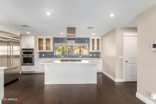 kitchen featuring island exhaust hood, a kitchen island, dark wood-type flooring, stainless steel appliances, and white cabinetry