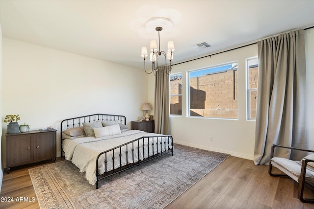 bedroom with a chandelier and light hardwood / wood-style flooring