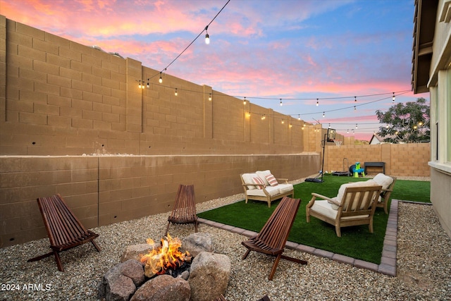 yard at dusk featuring an outdoor living space with a fire pit