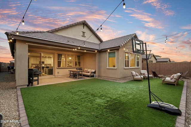 back house at dusk featuring outdoor lounge area and a patio area