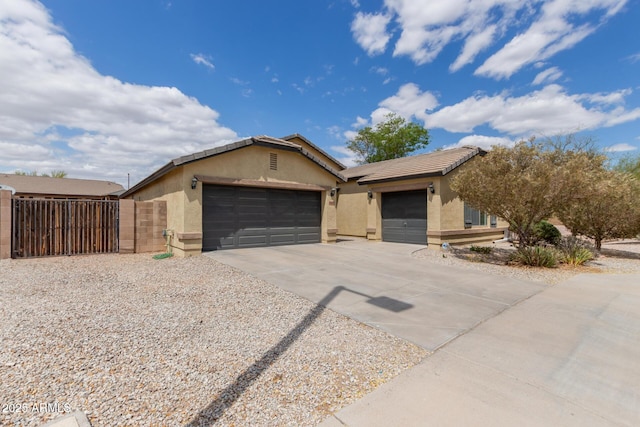 25212 W Maldonado Dr, Buckeye, AZ 85326 - view of front of home with an attached garage, a gate, stucco siding, and concrete driveway