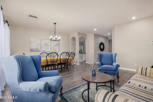 living room featuring an inviting chandelier and dark hardwood / wood-style flooring