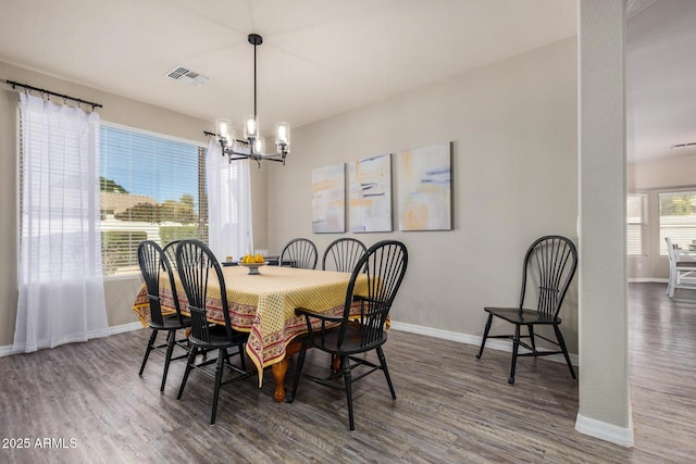 dining area featuring dark hardwood / wood-style flooring and a chandelier