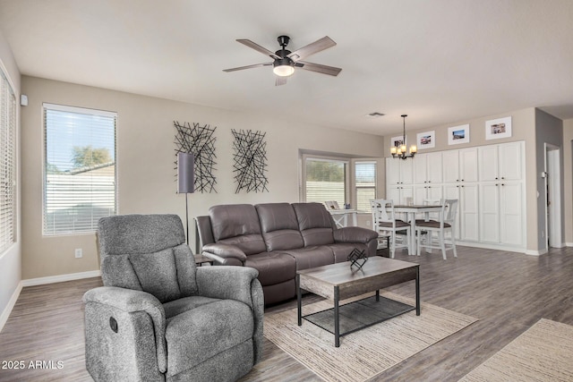 living room with dark hardwood / wood-style floors and ceiling fan with notable chandelier