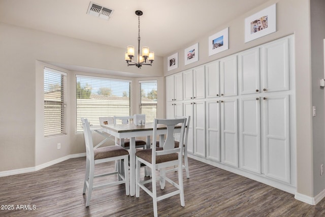 dining space with dark wood-type flooring and a notable chandelier