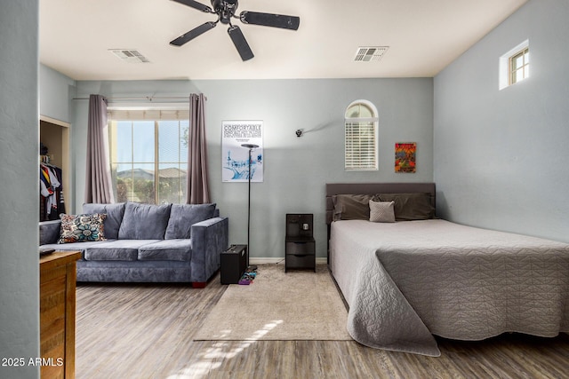 bedroom featuring multiple windows, light hardwood / wood-style flooring, and ceiling fan