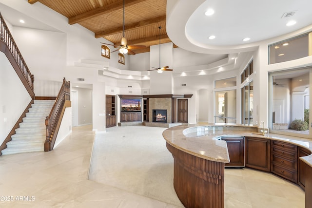 bar with wood ceiling, a ceiling fan, a sink, pendant lighting, and a tile fireplace