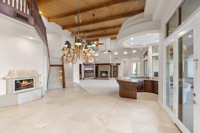 interior space with a premium fireplace, a chandelier, wood ceiling, beamed ceiling, and vanity