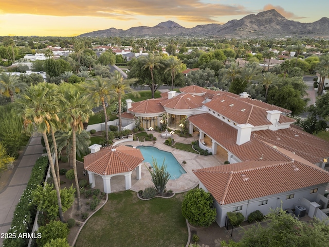 view of subject property with mountains and a pool