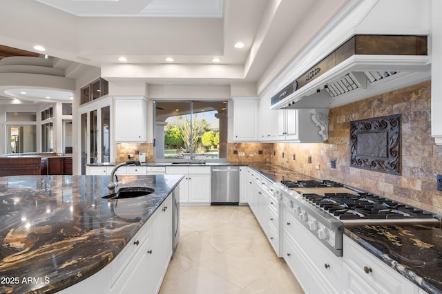 kitchen with a sink, appliances with stainless steel finishes, white cabinets, tasteful backsplash, and recessed lighting