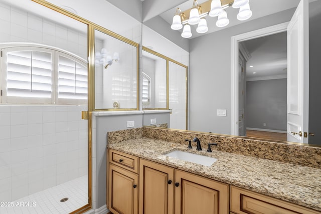 bathroom with a shower stall, vanity, and crown molding