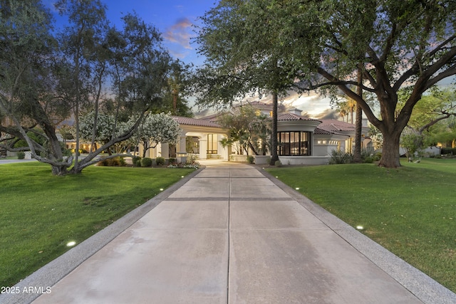 mediterranean / spanish-style house featuring a front lawn, a tile roof, and stucco siding