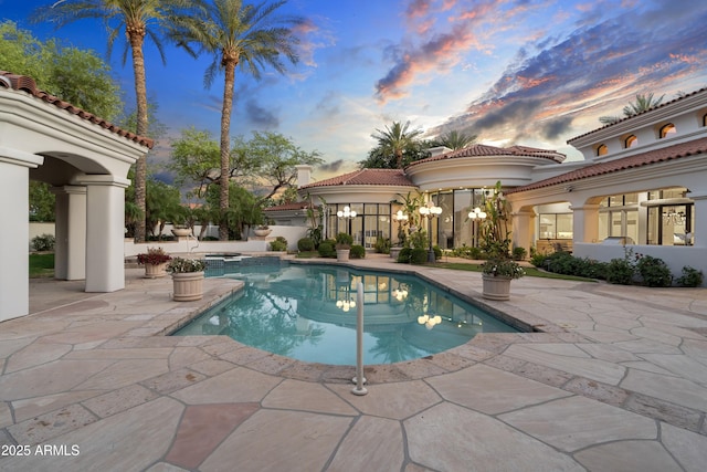 view of pool with a patio area and a pool with connected hot tub