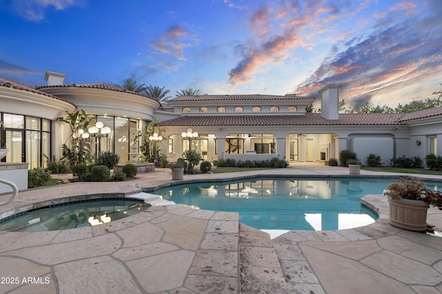 outdoor pool with an in-ground hot tub, a patio area, and a ceiling fan