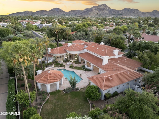 aerial view of residential area featuring a mountain backdrop and a pool