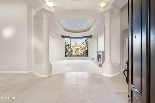 hallway featuring ornate columns and baseboards