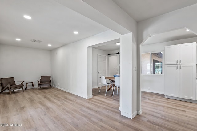 living area featuring light hardwood / wood-style floors and a barn door