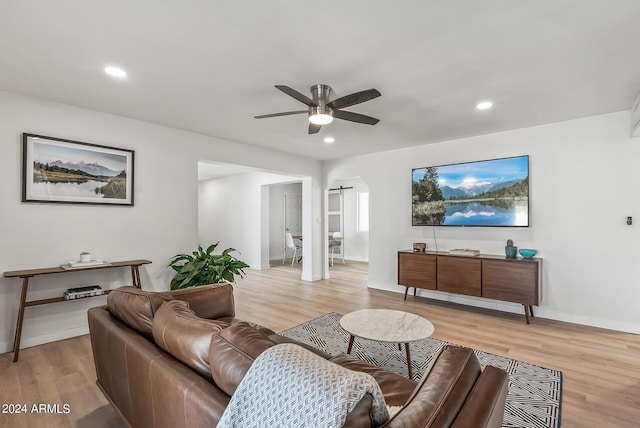 living room featuring light wood-type flooring and ceiling fan