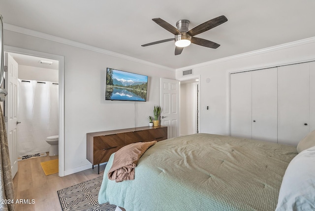 bedroom featuring ensuite bathroom, ceiling fan, light wood-type flooring, a closet, and crown molding