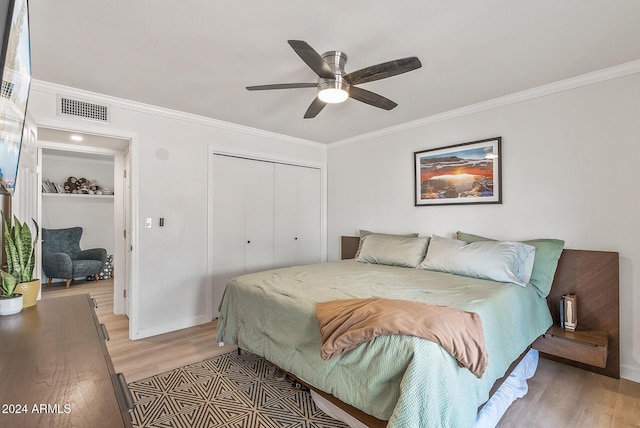 bedroom with ceiling fan, a closet, crown molding, and hardwood / wood-style flooring