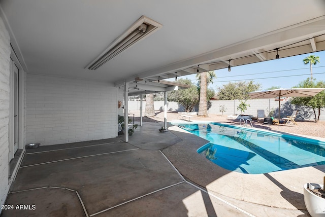 view of swimming pool with a diving board and a patio