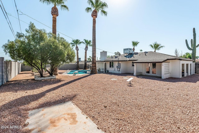 back of property featuring a fenced in pool and french doors