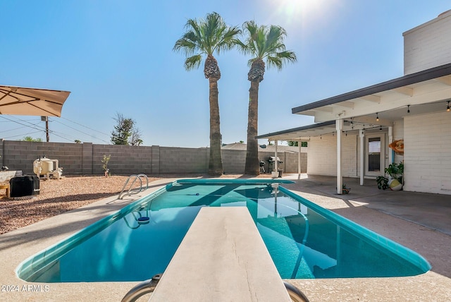 view of pool featuring a patio area and a diving board