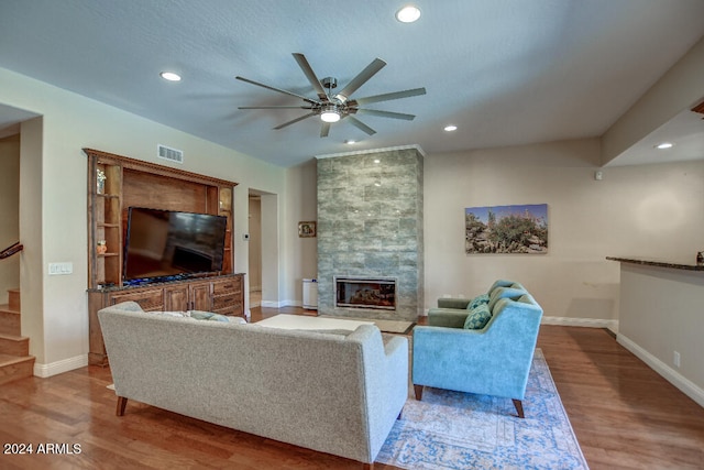 living room with ceiling fan, light hardwood / wood-style flooring, and a fireplace