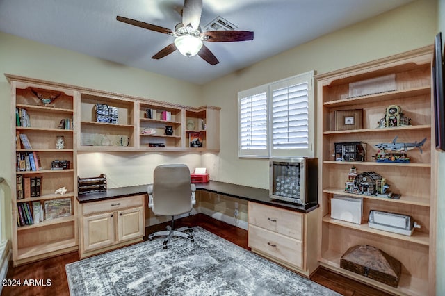 office space featuring built in desk, ceiling fan, dark hardwood / wood-style flooring, and a baseboard radiator